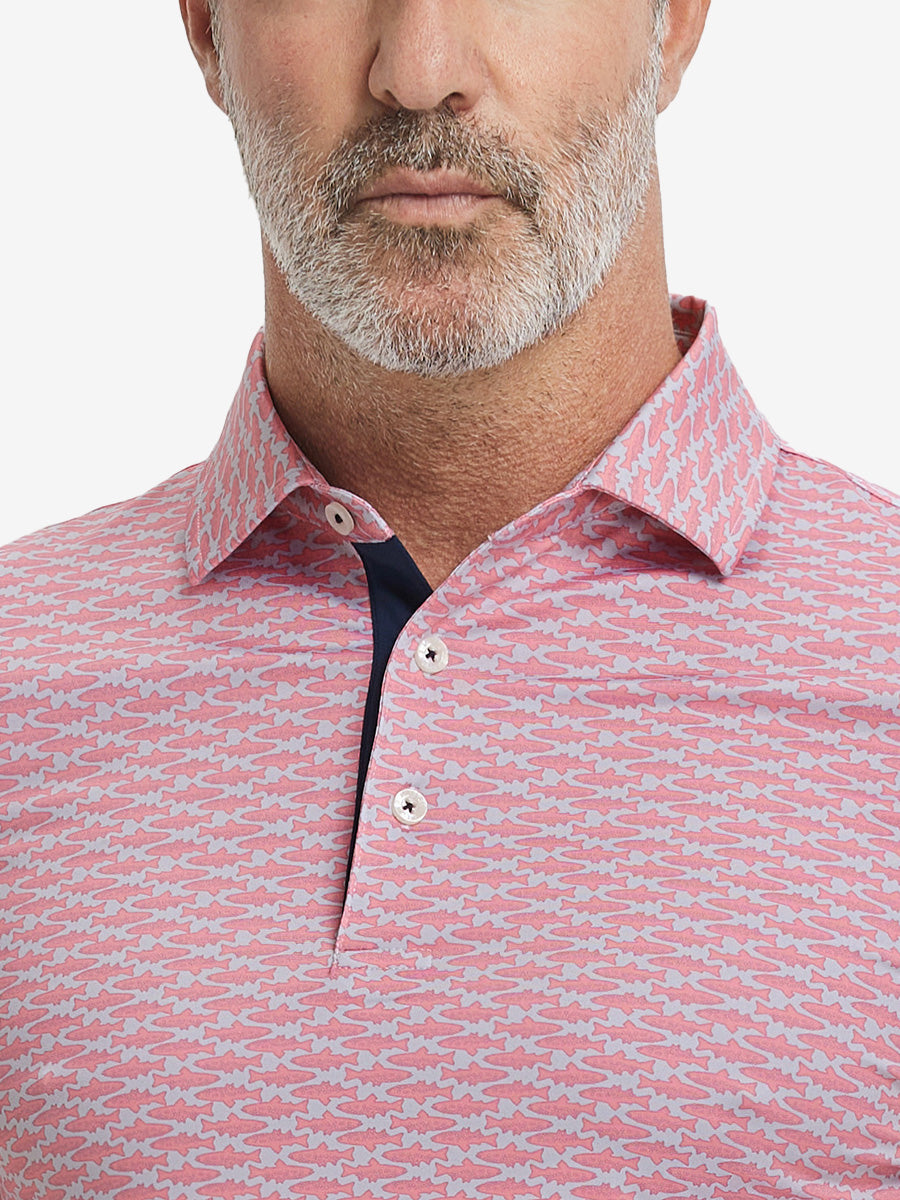 Close-up from nose to chest, showing collar and fabric pattern detail of the pink small fish polo shirt.
