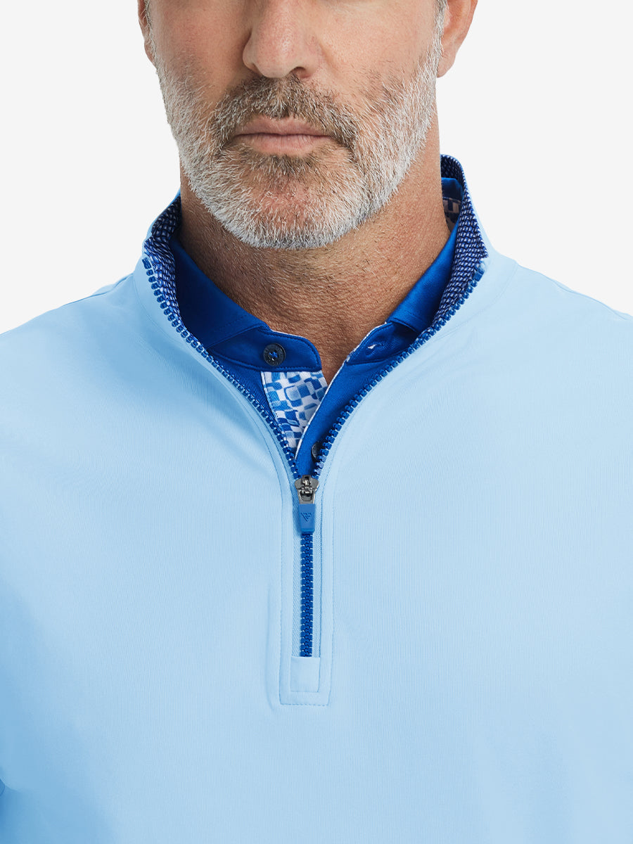 Close-up from nose to chest, showing collar detail and zipper of the light blue golf vest.
