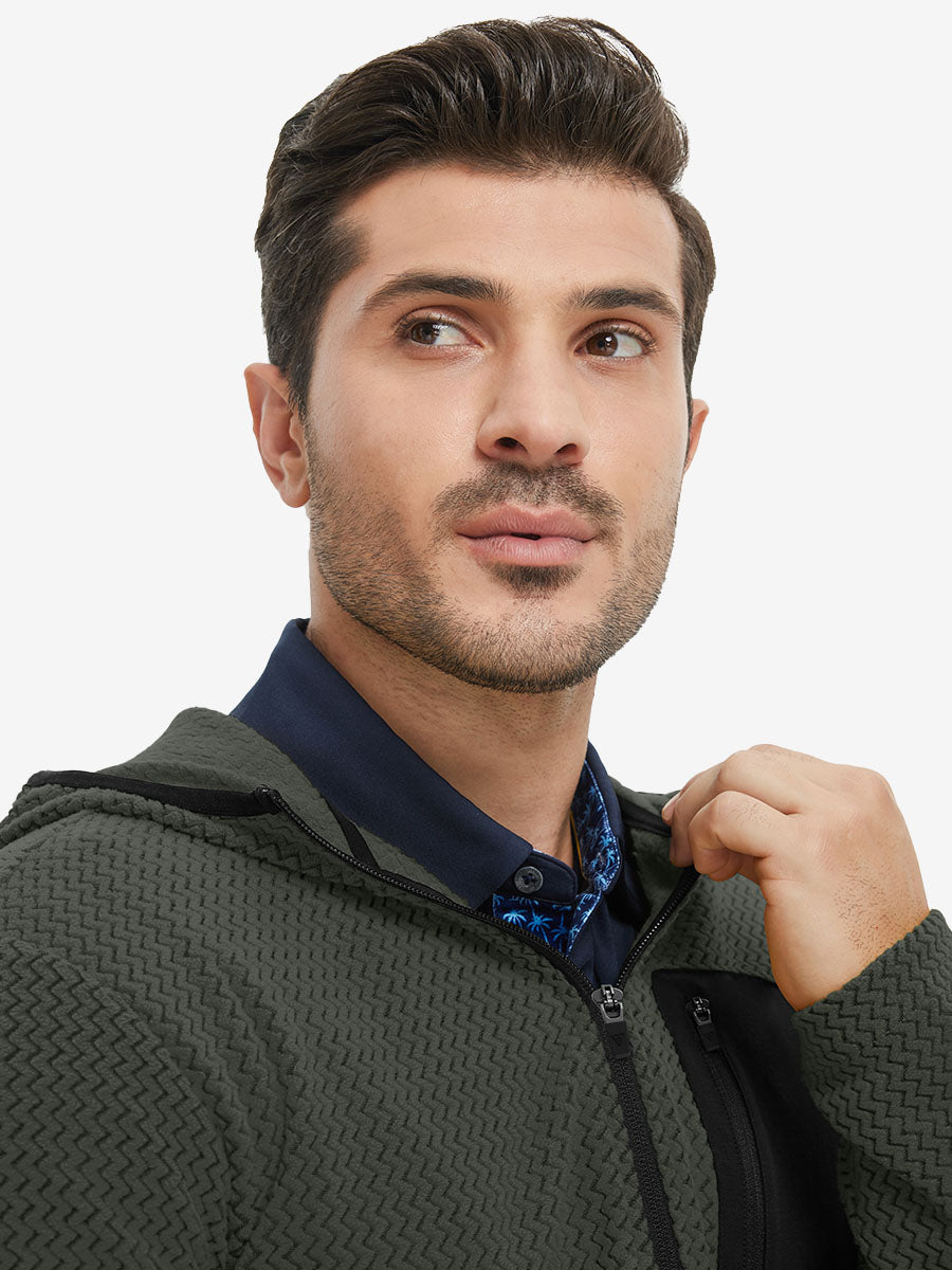 Model holding collar with one hand, wearing full zip fleece hoodied jacket in forest green.