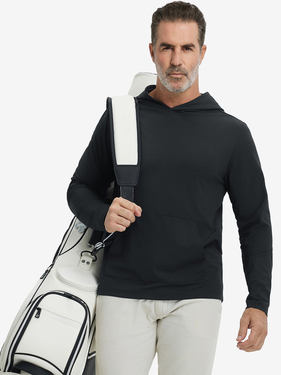 Model carrying golf bag, styled in black dry fit stretchy sweatshirts hoodie, modern athletic look.