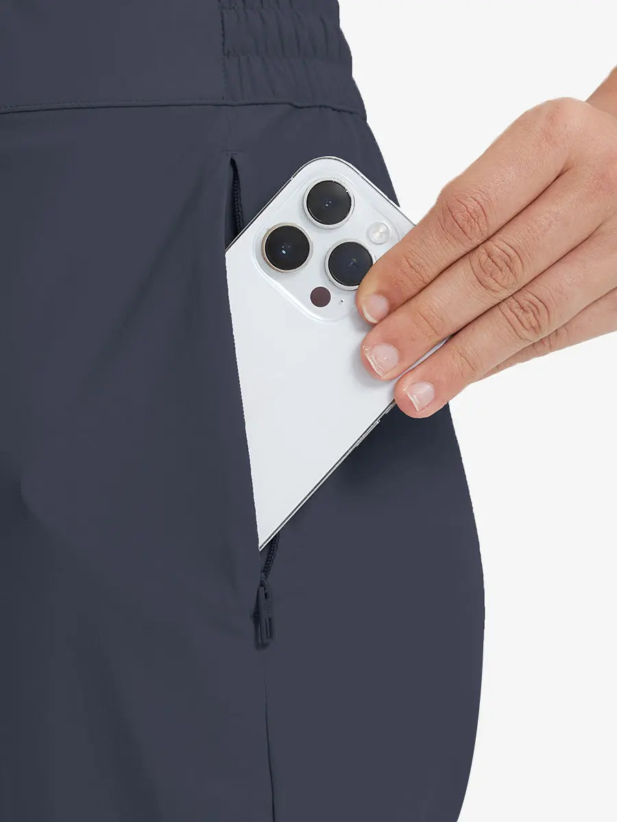 Detail shot of front side pocket holding an iPhone in NAVY Women's 7/8 Ankle Golf Track Pants.
