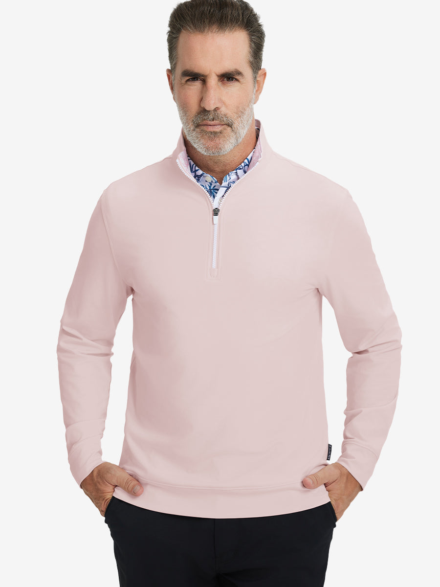 Front upper body view of model wearing lightweight golf quarter zip pullover in light pink, relaxed fit.