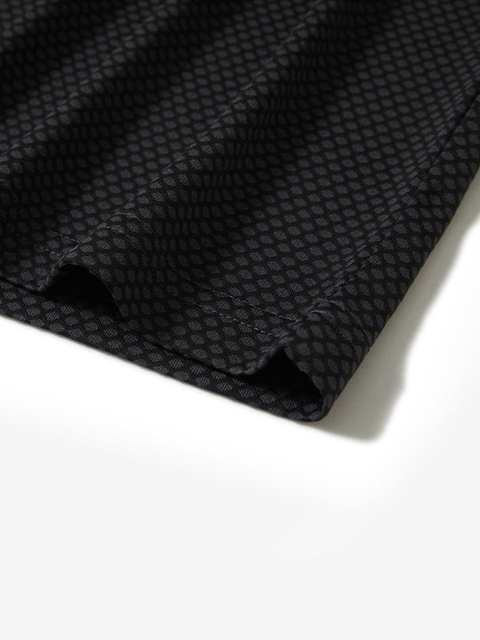 Hem detail of jacquard quarter zip pullover in dark grey/black, focusing on stitching and side vent finish.