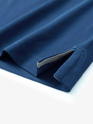 Detail view of the blue long sleeve pique polo, emphasizing the hem opening and functional details.
