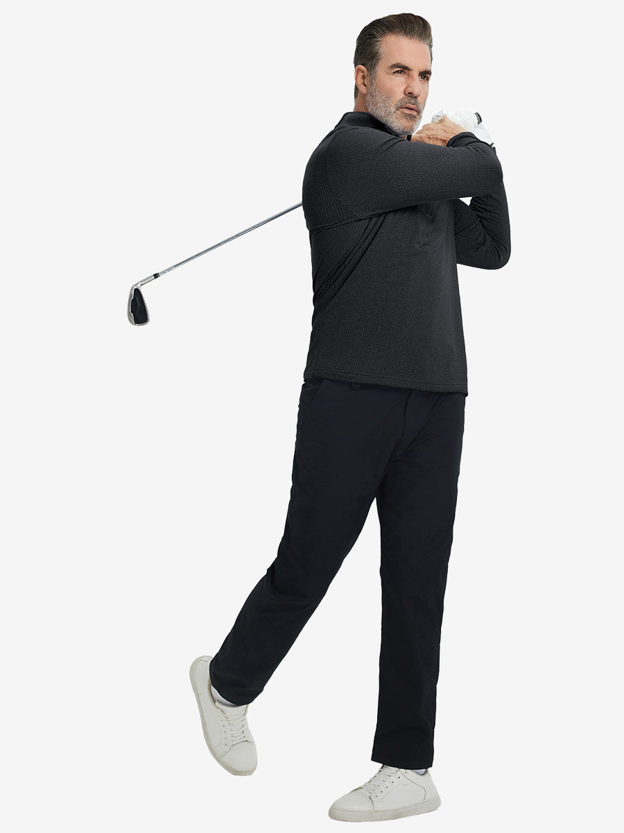 Model finishing golf swing, holding club, wearing casual fleece lined quarter zip pullover in black.